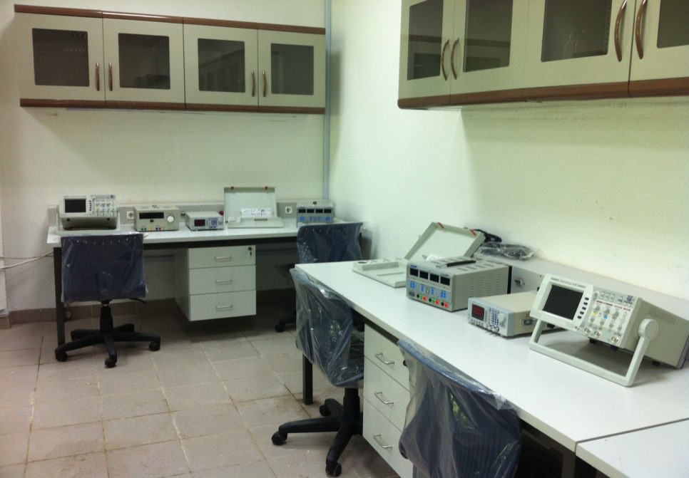 A clean, organized lab space with two workstations, each equipped with various electronic devices and chairs covered in plastic.
